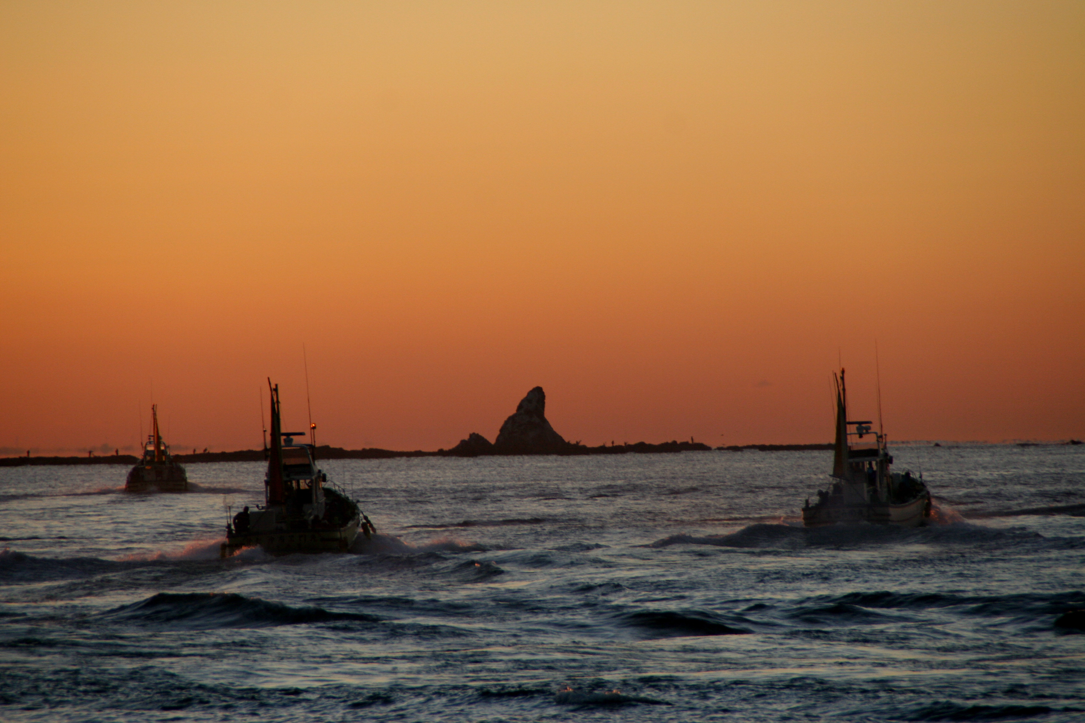 夕日の烏帽子岩と漁船